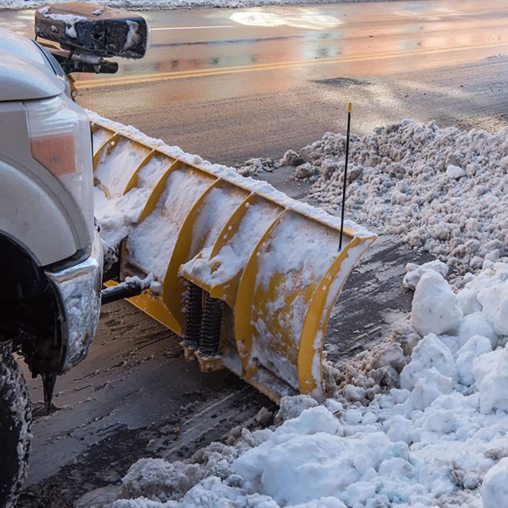 Plow truck clearing side of road of snow and ice in Delaware, OH.