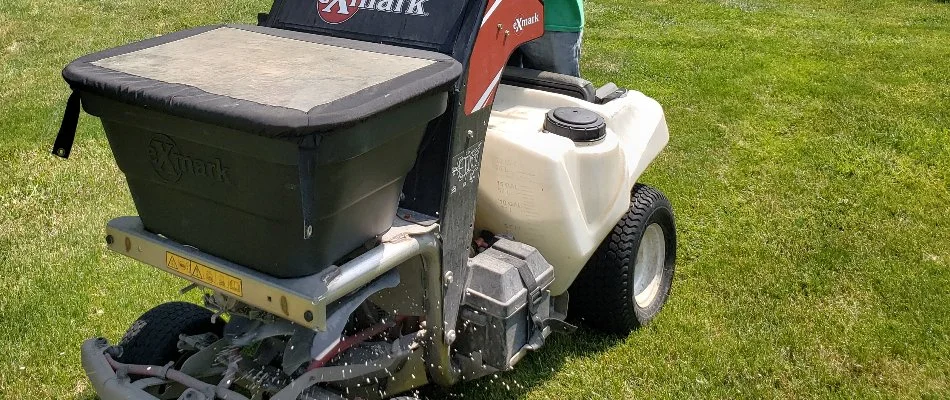 Granular fertilizer being applied on a green lawn in Delaware, OH.