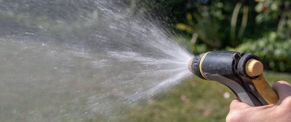 Hand holding a hose sprayer in Delaware, OH.