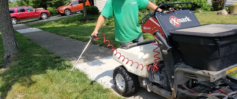 Worker applying a lawn care treatment in Delaware, OH.