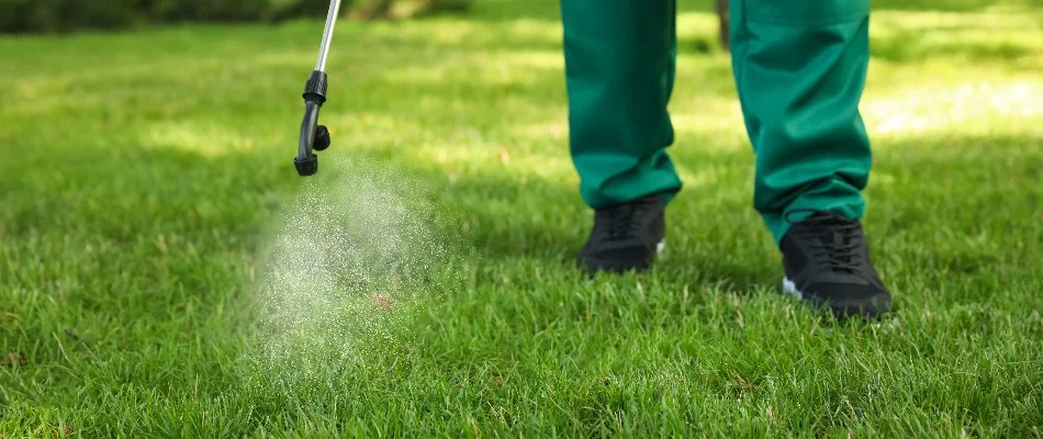 Worker applying a weed control treatment to a lawn in Delaware, OH.