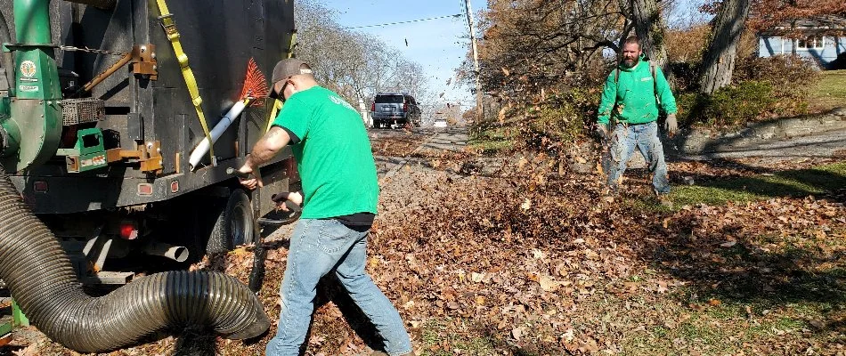 Men in Delaware, OH, blowing and vacuuming leaves.