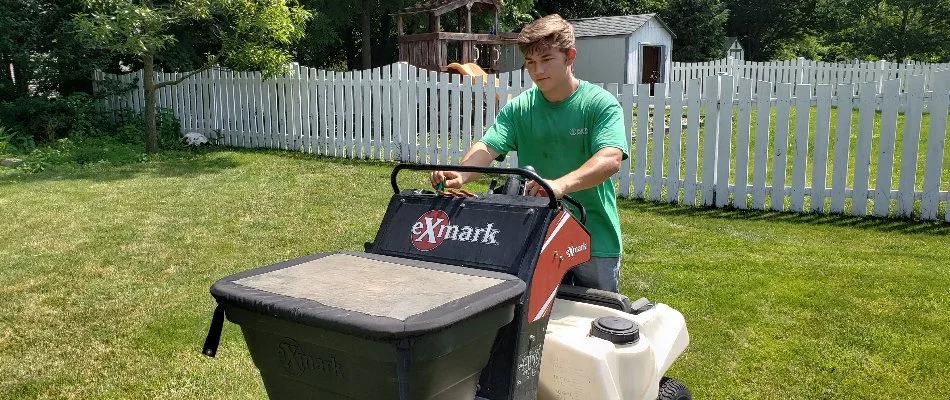 Professional applying granular fertilizer on a lawn in Delaware, OH.