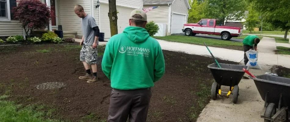 Professionals applying topdressing material on a lawn in Delaware, OH.