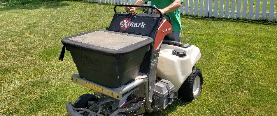 Tech on a granular spreader fertilizing a lawn in Delaware, OH.