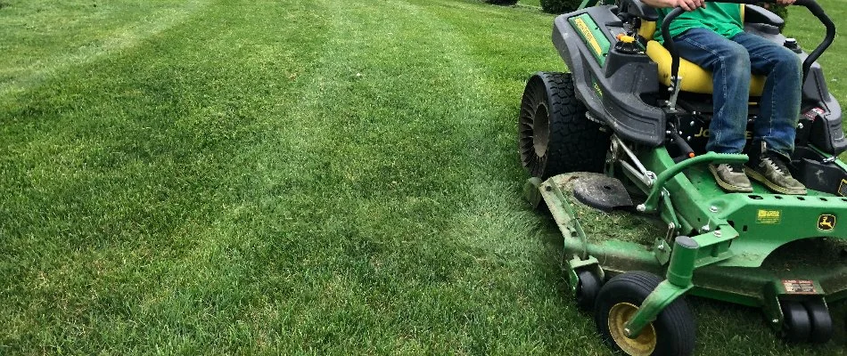 A worker in Delaware, OH, riding on a lawn mower.