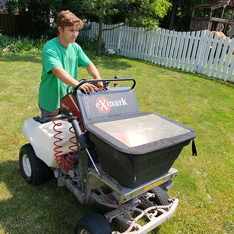 Lawn care worker using fertilizer equipment in Dublin, Ohio.