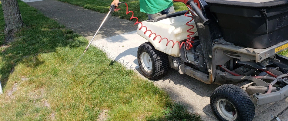A professional servicing lawn with liquid and granular treatments in Marion, OH.