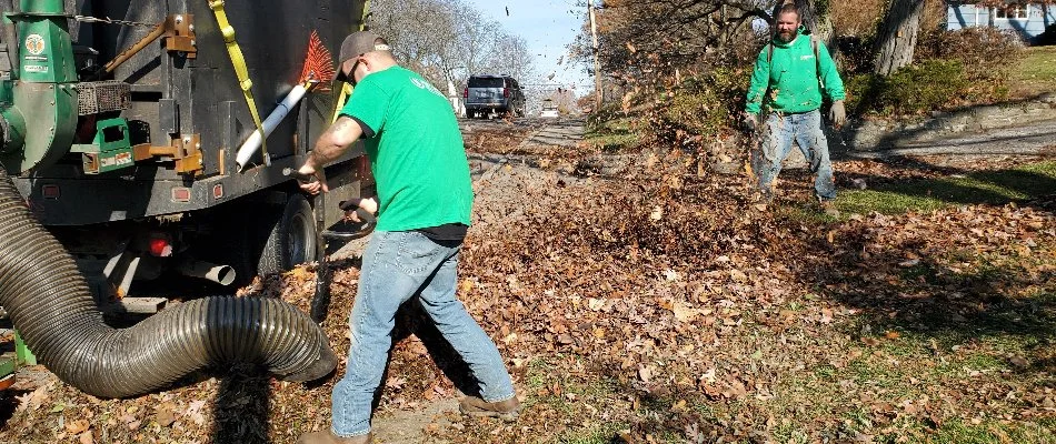 Worker sucking up leaves on a property in Delaware, OH.